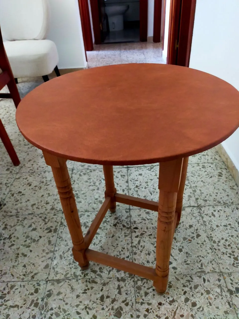 Mesa redonda de madera con tapa de cuero