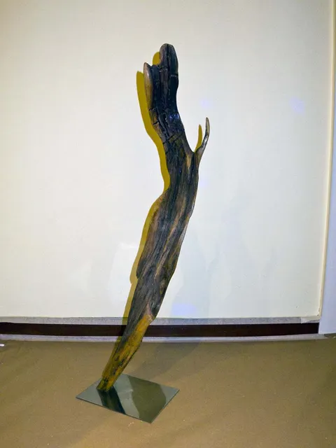 Escultura abstracta de madera y acero pulido.