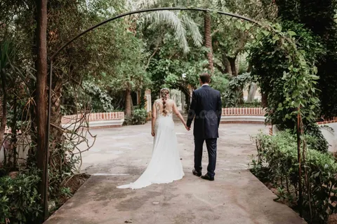Traje de novia y esmoquin en jardín