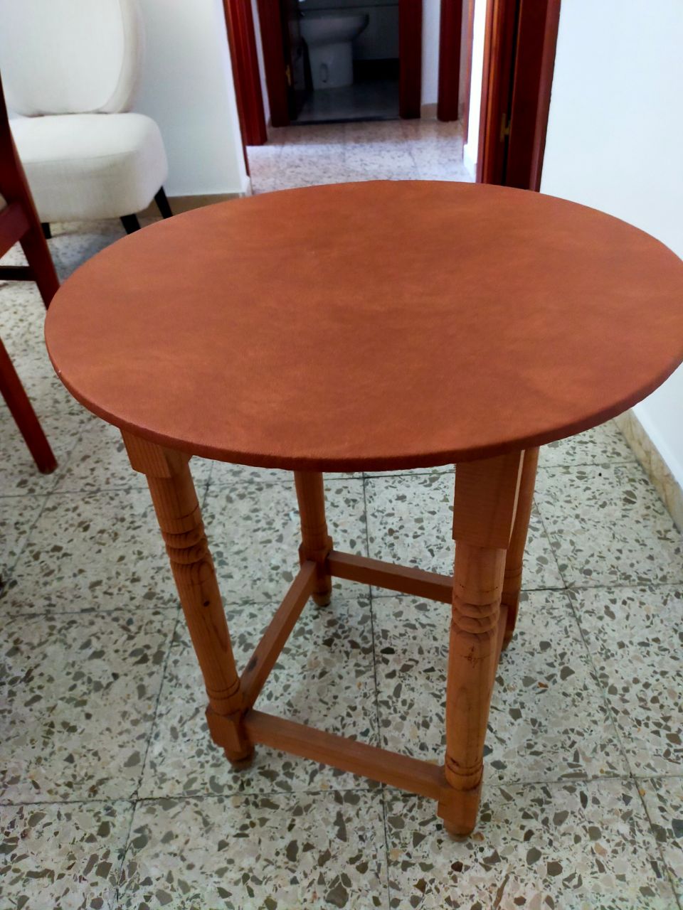 Mesa redonda de madera con tapa de cuero